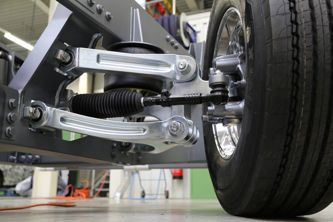 Truck suspension system The picture shows the independent wheel air suspension of a lightweight truck frame with double wishbone and a rack and pinion steering system.